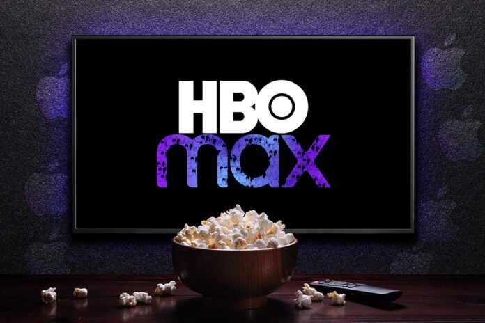 hbo-max-logo-on-tv-with-popcorn-bowl-and-remote-control-on-the-table-with-apple-tv-logos-sprinkled-on-the-wall