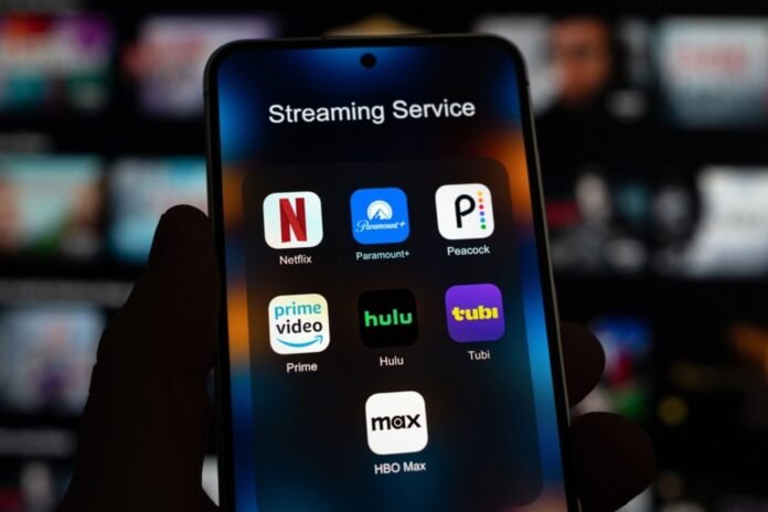 person-holding-a-phone-showing-streaming-apps-including-netflix-paramount-peacock-prime-hulu-tubi-hbo-max